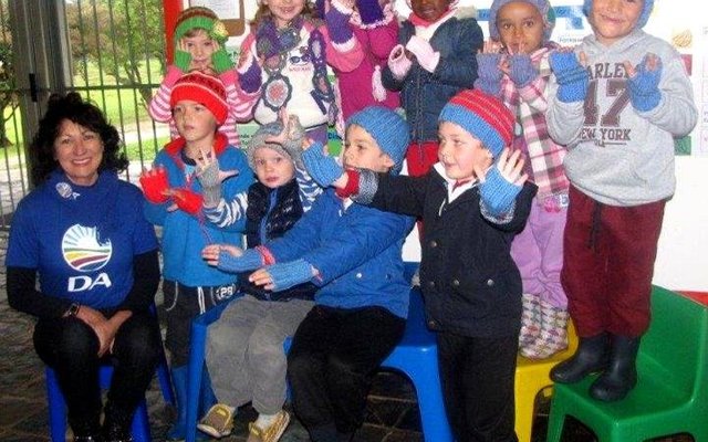 Die kleuters by Cool Kids is duidelik beÃ¯ndruk met hulle mussies en handskoene, met rdl Riana de Coning by hulle.  